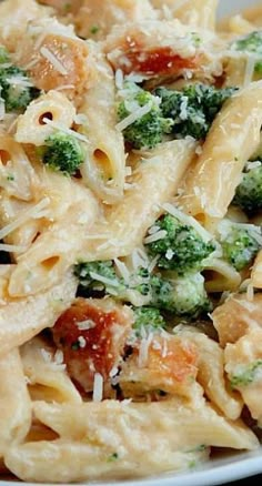 a pasta dish with broccoli, tomatoes and parmesan cheese on top