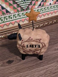 a sheep figurine sitting on top of a wooden floor next to a wall