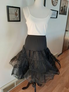 "Vintage Womens Black Nylon Full Circle Petticoat Slip/ Pin Up Rockabilly Half Slip Size M-L Very Good Vintage Condition. No Rips, Tears Or Stains. Elastic Has Probably Lost Some Of It's Stretch. If Replaced Could Fit A Size Small Also. .5\" Elastic Nylon Stretchy Top Section 2 17\" Tiered Stiff Nylon Ruffled Sections Nylon Undercoat Waist 30\"-43\" Hips 50\" Length 26\"" Summer Costume Petticoat With Attached Cancan, Retro Fitted Petticoat For Costume Party, Black Crinoline Full Skirt Petticoat, Black Full Skirt Crinoline Petticoat, Black Full Skirt Petticoat For Spring, Spring Black Full Skirt Petticoat, Can-can Petticoat For Costume Party, Stretch Petticoat With Ruffles For Dance, Black Ruffled Full Skirt Petticoat