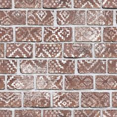 an old brick wall with white and brown designs