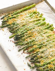 asparagus covered in parmesan cheese on a baking sheet