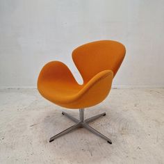 an orange chair sitting on top of a white floor