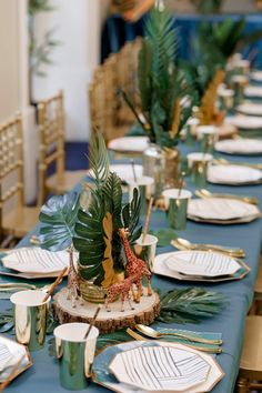 a table set with plates and place settings for an animal themed dinnereon party or baby's first birthday