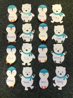 there are many polar bear magnets on the table with name tags attached to them