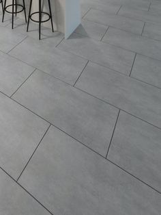 a kitchen with grey tile floors and bar stools