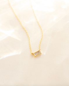 Baguette diamond necklace, Rectangle necklace, Pendant necklace, Dainty diamond necklace, Stack necklace, Baguette jewelry, Statement piece --- Our Colette Necklace features a dreamy bezel set sparkling white CZ Stone on our dainty cable chain. Dress this modern necklace up with your favorite layering chain or wear solo for the perfect stand out style. Pair with our Eve Ring for all of your bezel dreams!  Details: -Gold Filled -16" + 2" Extender  -Bright CZ Stone -Waterproof, Hypoallergenic, Tar Dainty Gold Baguette Cut Necklace, Rectangular Diamond Cut Necklace, Square Pendant Necklace With Baguette Diamonds For Gift, Dainty Baguette Cut Diamond Necklaces, Dainty Necklaces With Diamond Baguette Accents, Fine Jewelry Rectangular Baguette Diamond Necklace, Dainty Necklaces With Diamond Baguette Cut, Dainty Baguette Diamond Necklace, Delicate Baguette Diamond Necklace Gift