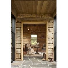 the inside of a log cabin with stone flooring