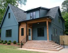 a blue house with steps leading up to the front door and second story porch area