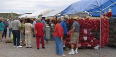 people are standing around at an outdoor market