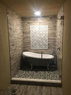 a bath tub sitting inside of a bathroom next to a walk in shower