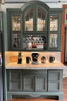 a kitchen with green cabinets and white counter tops