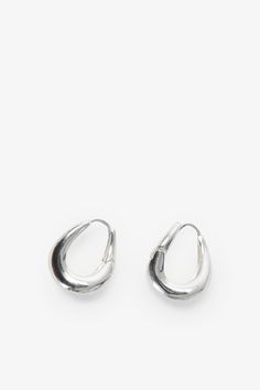 Find poetry in the everyday with our Sisley Hoops. Elegant and ever-so-chunky, these oval ornaments are crafted from sterling silver with either 18k gold or white gold plating to complement any look. Featuring a post back closure and polished finish. Each pair includes a Marcella-branded vegan leather travel case for safe storage and easy travel. | Available in one size. Approximately .5” (1.5 cm) in height, and .3" (.8 cm) in width. In silver, white gold plated sterling silver. In gold, 18KT ye Everyday Teardrop Jewelry With Shiny Finish, Everyday Oval Jewelry With Shiny Finish, Oval Jewelry With Shiny Finish For Everyday, Sterling Silver Rounded Jewelry, Silver Oval Earrings For Everyday, Trendy Oval Jewelry For Everyday, Silver Oval Tarnish Resistant Hoop Earrings, Silver Oval Jewelry For Everyday, Safe Storage