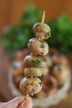 a person is holding up some food on skewers with toothpicks in it