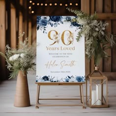 a sign that says 90 years loved with flowers and candles in front of the sign