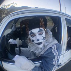 a person in a clown mask sitting in the back seat of a car