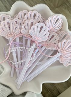 a white bowl filled with lots of pink paper flowers