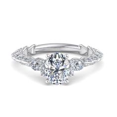 an oval cut engagement ring with three stones on the band and side stones in white gold