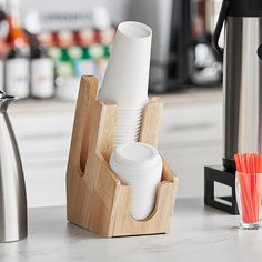 the cups are stacked up on the counter next to the coffee pot and carafe