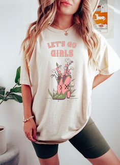 Lets Go Girls t-shirt. These tees are Comfort Colors and are made to last using premium ringspun cotton, this creates an vintage-soft shirt. The soft-washed, garment-dyed fabric brings extra coziness to your wardrobe while the relaxed fit makes it an excellent daily choice. ✦ 100% Ringspun Cotton ✦ Color: Ivory, Pepper, Orchid, Black ✦ Relaxed fit ✦ Medium fabric ✦ Sewn-in twill label ✦ Eco-friendly, Ethically Made & Sweatshop Free ✦ Printed to order with non-toxic ink ✦ Durable and Long-lasting Spring Letter Print T-shirt, Cute Spring Letter Print T-shirt, Cute T-shirt With Text Print For Spring, Cute Spring T-shirt With Text Print, Cute Pre-shrunk T-shirt For Spring, Cute Pre-shrunk Spring T-shirt, Cute Screen Print Tops For Spring, Cute Tops With Screen Print For Spring, Cute Spring Tops With Screen Print