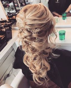 the back of a woman's head with long blonde hair in a half - up braid