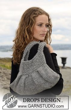 a woman with long hair wearing a gray knitted bag