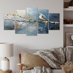 a living room scene with a couch and paintings on the wall, including a bird perched on a branch