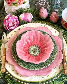 there is a plate with pink flowers on it next to other plates and utensils