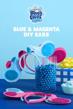 blue and magenta diy ears are sitting on a table next to other items