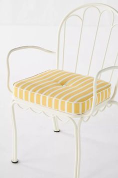 a white chair with yellow and white striped cushion