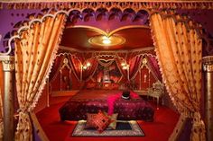 an elaborate bedroom with red carpet and gold curtains