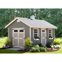 a small shed with two windows on the roof and some flowers in the front yard