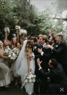 a bride and groom are surrounded by their wedding party