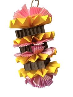 a bunch of cupcakes are hanging from a string on a white background with pink, yellow and brown paper