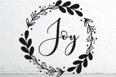 the word joy in a wreath with leaves and berries around it, on a white background