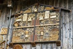 an intricately decorated wooden wall with birdhouses and other decorative objects on it's side