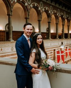 a bride and groom pose for a photo in the great hall of liverpool town hall