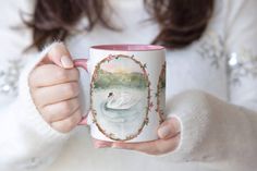 a woman holding a coffee mug with a painting on it's front and side