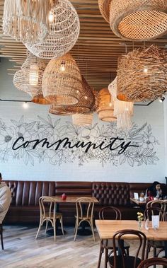 a restaurant with wooden tables and chairs, chandeliers hanging from the ceiling above them