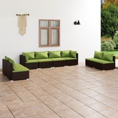 a living room filled with furniture next to a green couch and chair on top of a tiled floor