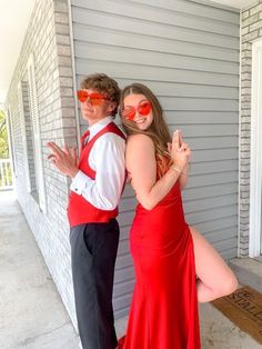 a man and woman dressed in formal wear posing for the camera with their arms around each other