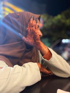 a man sitting at a table with his hands on his face