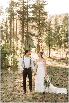 a bride and groom holding hands in the woods