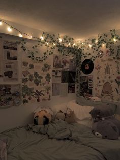 there is a bed with stuffed animals on it and lights strung from the ceiling above