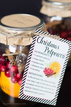 a mason jar filled with christmas decorations on top of a table next to a tag