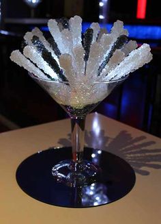 a martini glass filled with ice on top of a table in a restaurant or bar