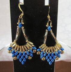 a pair of blue and gold earrings on display