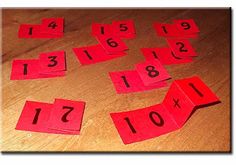 red paper cut out to spell numbers on a wooden table with one missing the number