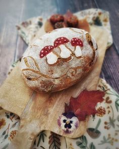 a loaf of bread sitting on top of a wooden cutting board next to a leaf