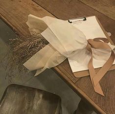 a piece of paper sitting on top of a wooden table next to a brown chair