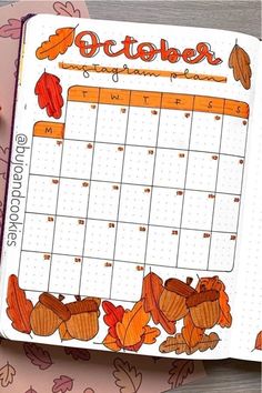 an open planner with autumn leaves and acorns on it